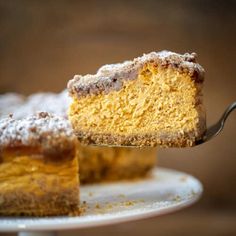 a piece of cake on a plate with a fork in it and someone holding the slice