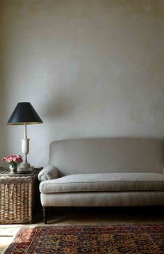 a white couch sitting next to a lamp on top of a table