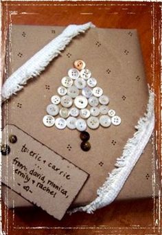 a christmas tree made out of buttons on a piece of brown paper with white fringe