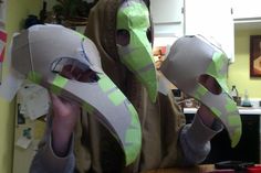 two people wearing paper masks in the kitchen