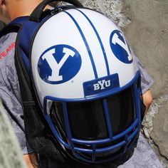 a young boy wearing a white and blue football helmet