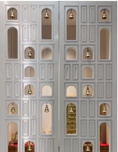 a tall white door with bells on each side