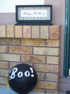 a balloon with the word boo written on it sitting in front of a brick wall