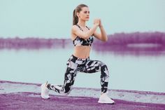 a woman is running on the beach in her sports bra top and leggings