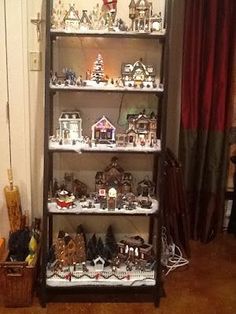 a tall shelf filled with lots of small christmas decorations and figurines on top of it