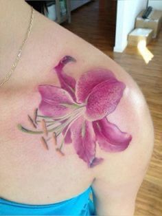 a woman's shoulder with a pink flower on the left side of her body