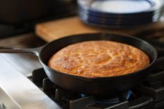 a skillet sitting on top of a stove next to plates