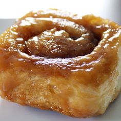 a close up of a doughnut on a white plate with sauce in the middle