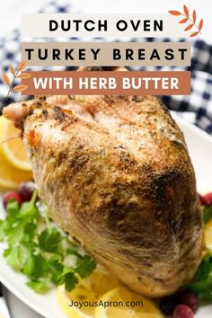 a turkey breast on a plate with herbs and lemons in the background text overlay reads dutch oven turkey breast with herb butter