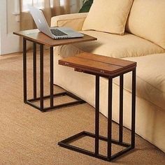 a laptop computer sitting on top of a wooden table next to a couch in a living room