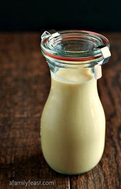 a glass jar filled with milk sitting on top of a wooden table