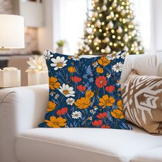 a living room with a christmas tree in the background and pillows on the couches