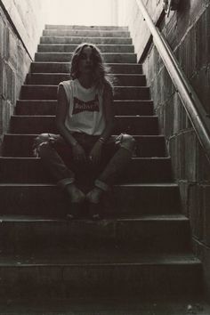 a woman sitting on top of a set of stairs