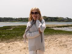 a woman is standing on the beach talking on her cell phone