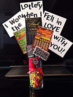 a bottle filled with candy sitting on top of a table next to a sign that says, i won't tell in the love with you