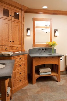 a large bathroom with wooden cabinets and marble counter tops