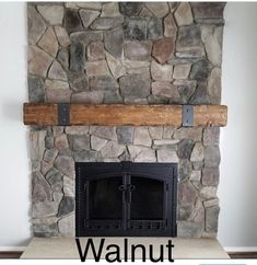 a stone fireplace with a wooden mantle in the middle