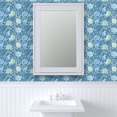 a white sink sitting under a mirror next to a wall mounted faucet in a bathroom