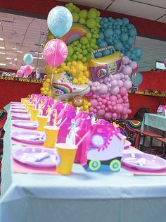 a table set up with balloons, plates and cups