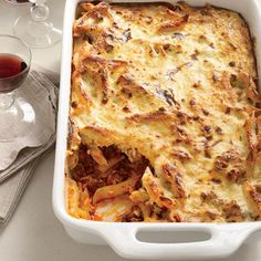 a casserole dish with meat and cheese in it on a white tablecloth