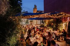 a group of people sitting at tables outside