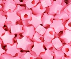 pink plastic beads with holes in the middle and one hole at the top, are shown close up