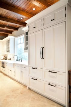 a kitchen with white cabinets and wood ceilinging in the background is an instagram page