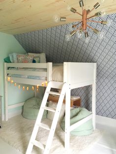 a room with bunk beds and lights on the ceiling is decorated in pastel colors