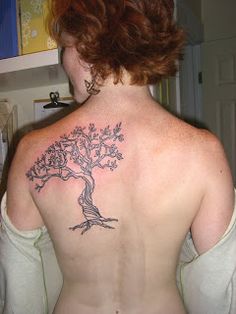 a woman with a tree tattoo on her back