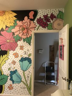 an open door leading into a room with flowers painted on the wall