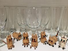 there are many wine glasses on the table with mice and bead decorations around them