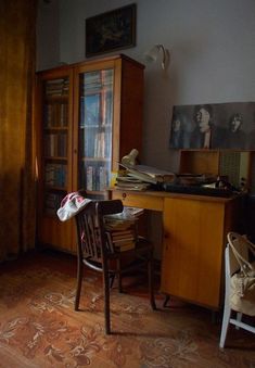 an old desk and chair are in the corner of this room with bookshelves