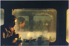 two people sitting at a table in front of a window