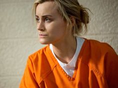 a woman in an orange prison uniform looking off to the side