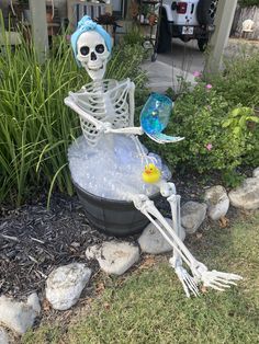 a skeleton sitting on top of a bucket filled with water