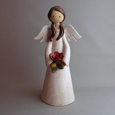 an angel figurine holding a rose in its hands