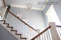 a staircase with white railing and chandelier