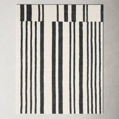 a black and white striped rug on top of a gray wall with an area rug underneath it