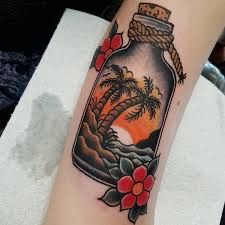 a bottle filled with water and palm trees on top of a white towel next to a red flower