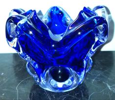 a blue glass vase sitting on top of a table