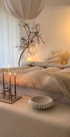 a bed with two candles and a vase on it