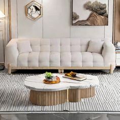 a living room with white couches and gold accents on the walls, along with a coffee table