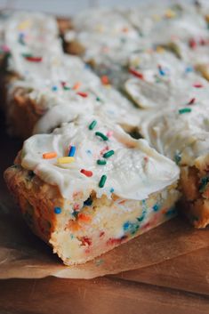 a cake with white frosting and sprinkles is on a cutting board