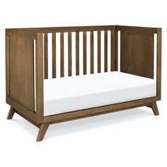 a wooden crib with white sheets on the bottom and side rails, in front of a white background