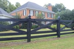 a black fence in front of a large house