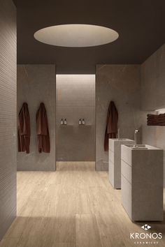 a bathroom with two sinks and three towels hanging on the wall next to each other