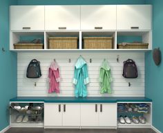 an organized laundry room with white cabinets and blue walls