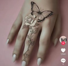 a woman's hand with a butterfly and rose tattoo on it