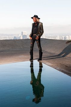 a man standing on top of a roof next to a body of water with buildings in the background