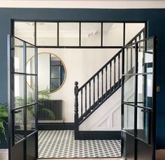 an entry way with black and white checkered flooring, two sets of doors leading to the second story